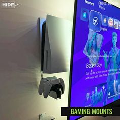 a flat screen tv mounted to the side of a wall next to a game controller