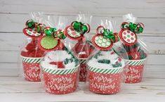 four red and green christmas gift bags filled with candy