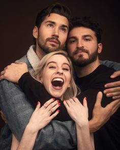 two men and a woman hugging each other