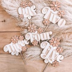 four cake toppers with flowers and the words we love you in white letters on them