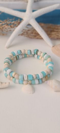 TitiTataStore.etsy.com Always FREE SHIPPING and a FREE GIFT! I Will Ship Within 24 Hours! Description: A Beautiful Set of 2 Coastal Style Ocean Inspired Beachy Bracelets. Materials: Aqua Shell Beads, 6mm Natural Matte Riverstone Beads, 6mm Natural Wood Beads, White Heishi Seashell Beads, and 6mm Rondelle Magnesite Beads.  A coastal Clam Shell charm adorned this Beachy Style set. Every bracelet is handmade using a high-quality elastic stretch cord for durability. Size: Each bracelet is suitable for a wrist circumference of about 7". Final Touch: Your bracelet will be nicely packed in a Burlap Gift Bag. ❤ All orders are shipped FREE via USPS First Class Mail with tracking number. ❤ If you would like a different size, just send me a note and I will resize it for you. Please visit my store for Beach Inspired Bracelets, Bracelets Seashell, Beachy Bracelets, Girls Trip Gifts, Burlap Gift Bags, Seashell Bracelet, Coastal Jewelry, Ocean Style, Beachy Jewelry