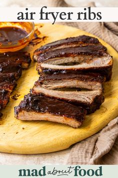 slices of bbq ribs on a cutting board with barbecue sauce