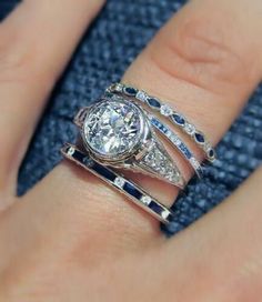 a woman's hand with three different rings on top of her finger and the other ring