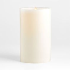 a white candle is lit on a white background