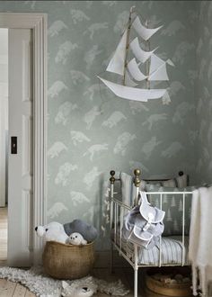 a baby's room with a sailboat wallpaper