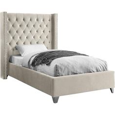 a white bed with an upholstered headboard and foot board