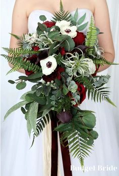 a bridal holding a bouquet of flowers and greenery