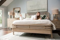 a woman laying on her bed reading a book