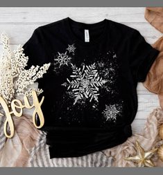 Wear this snowy tee through Christmas, New Years, and the rest of the winter season! This snowflakes t-shirt features beautiful,  falling snow. A great gift for winter sports enthusiasts! Everyone needs the perfect t-shirt to complement an everyday, laid-back look. The ideal top for so many occasions, this lightweight cotton tee will keep you comfy and looking smart. * 100% combed and ring-spun cotton (Heather colors contain polyester) * Fabric weight: 4.2 oz/yd² (142 g/m²) * Pre-shrunk fabric * Side-seamed construction * Shoulder-to-shoulder taping * Blank product sourced from Guatemala, Nicaragua, Mexico, Honduras, or the US This product is made especially for you as soon as you place an order, which is why it takes us a bit longer to deliver it to you. Making products on demand instead Snowflake Shirt, Holiday Party Tops, Winter Tees, Ski Shirts, Winter T Shirts, Falling Snow, Holiday Shirt, Sports Tees, Christmas T Shirt