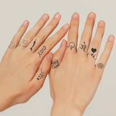 two women's hands with tattoos on their fingers