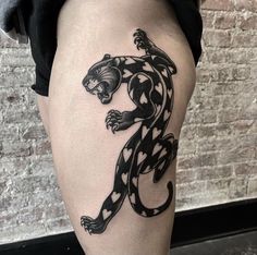 a black and white tattoo on the thigh of a woman's leg with a lizard