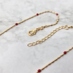 This rouge, 18k gold plated necklace features small red gemstones, set on a delicate fine chain.    Embrace the symbolism of passion and elegance with our Rouge Beaded Gold Plated Fine Necklace, a timeless piece that embodies the rich essence of love and sophistication in every delicate detail.  This jewellery arrives beautifully packaged and ready to gift. It would make a really thoughtful and meaningful birthday gift, Christmas gift, Mother's Day gift, Valentine's Day gift, anniversary gift, gift for Mum, gift for Grandma, gift for wife, gift for friend, gift for her, gift for best friend, gift for Mom, thank you gift, wedding gift, easter gift or gift for any other special occasion. JEWELLERY CARE GUIDE Our jewellery is lovingly handmade using high quality materials and semi-precious ge Red Minimalist Necklace With Delicate Chain, Minimalist Red Necklace With Delicate Chain, Red Long Necklace With Adjustable Chain, Red Dainty Jewelry With Round Beads, Elegant Red Beaded Necklace With Lobster Clasp, Red Dainty Round Beaded Jewelry, Elegant Festive Necklace With Delicate Chain, Dainty Red Round Bead Jewelry, Dainty Red Round Beaded Jewelry