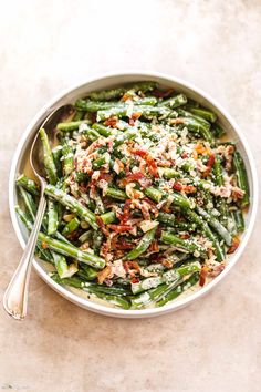 a white bowl filled with green beans and bacon