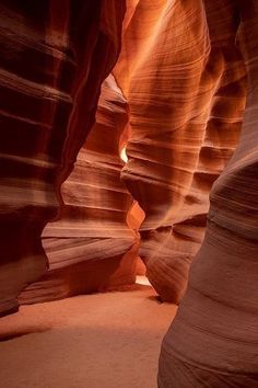 a narrow slot in the side of a canyon with light coming from it's windows