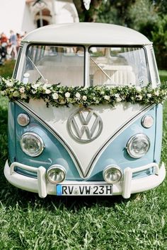 an old vw bus decorated with flowers and greenery