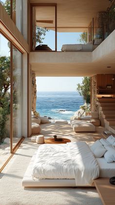 a bedroom with an ocean view is shown in this image, the bed has white linens and pillows on it