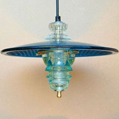 a light fixture hanging from a ceiling with a blue glass cover on it's side