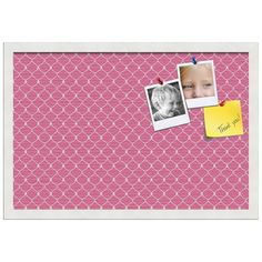 a pink wall with pictures and post it notes attached to it