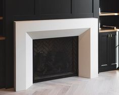 an empty fireplace in a black and white living room