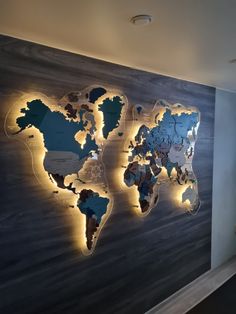 the world map is lit up with lights on it's wall in an office