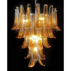 a chandelier made out of blown glass with yellow lights hanging from the bottom