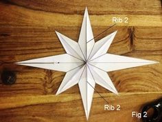 an origami star is shown on a wooden table with scissors and other items