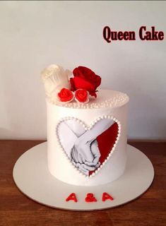 a white cake decorated with red roses and two hands