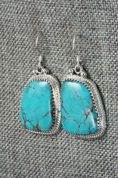 These Kingman turquoise and sterling silver earrings were made by Navajo silversmith Sharon McCarthy. The back is signed RB and stamped .925.Length: 1 1/2"Width: 3/4"Free shipping on all orders! We ship with USPS and always include tracking. All orders ship within a day of payment.Returns are accepted up to 30 days after you receive your order. Just send us a message. Our shop offers cash back or store credit. The item must be returned in new condition. Nickel Free Sterling Silver Western Earrings, Handmade Western Turquoise Earrings, Turquoise Dangle Earrings Western Style, Western Turquoise Dangle Earrings, Western Style Turquoise Nickel-free Earrings, Western Turquoise Nickel-free Earrings, Turquoise Nickel-free Western Earrings, Western Style Nickel-free Turquoise Earrings, Artisan Nickel-free Turquoise Hoop Earrings