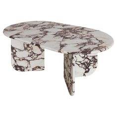 a white and black marble table with an oval shaped design on the top, in front of