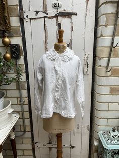 Antique French white brushed cotton blouse with lace collar initials LM size M. 100% Cotton - warm brushed cotton. Collar, button tab and button cuffs, all with embroidered lace trim, initials LM at hem. Size: Chest: 40 inches; Shoulder to shoulder: 15.5 inches; Sleeve length: 20 inches; arm inseam: 17 inches; Length: 23.5 inches. Weight: allow up to 1 kg once packed. Condition commensurate with age and use - a very small faint mark on front and original darn at back of neck but hidden by collar White Linen Blouse With Spread Collar, Classic Cotton Top With Ruffled Collar, Classic Peter Pan Collar Top For Fall, White Spread Collar Shirt For Fall, Fitted Cotton Tops With Detachable Collar, Casual White Shirt With Ruffled Collar, White Cotton Blouse With Buttons, Fall Cotton Collared Blouse, Ruffled Collar Button Top For Daywear