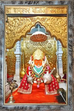 an idol sitting in front of a golden wall