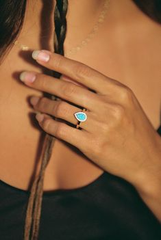 a woman's hand with a ring on her finger and a necklace around her neck