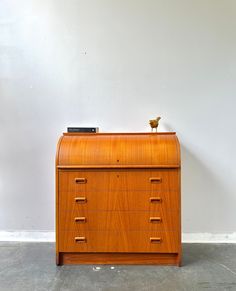 an old wooden filing cabinet with two birds on top