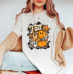 Fall Smiley Face Shirt, Cute Pumpkin Shirt, I Love Fall Shirt, Thanksgiving Shirt, Retro Fall Shirt, Vintage Autumn Leaves Tee, Fall Lovers ❀DETAIL❀ For printing, we use Bella Canvas and Gildan SoftStyle brand shirts, which are the best in the industry. *Bella Canvas -unisex size -4.2 oz. -Solid colors are 100% Combed Cotton and Ring-Spun Cotton. -Athletic Heather 90% Combed and Ring-Spun Cotton, 10% Polyester -All Heather CVC Colors 52% Combed and Ring-Spun, 48% Polyester *Gildan SoftStyle -uni Cute White Tops For Fall, Cute Pre-shrunk Shirt For Fall, White Sublimation Print Top For Fall, Fall Cotton Graphic Tee Shirt, White Screen Print T-shirt For Fall, Graphic Tee With Sublimation Print For Fall, Graphic Cotton Tee For Fall, Casual Fall Shirt With Graphic Print, Trendy Fall Short Sleeve Shirt