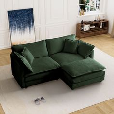 a green sectional sofa sitting on top of a white rug next to a pair of slippers