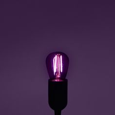 a purple light bulb sitting on top of a black table