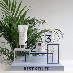 three different types of skin care products sitting on top of a table next to a plant