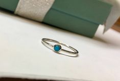 This sweet little ring is made entirely of sterling silver and features a dainty little 3mm natural blue turquoise. The band measures exactly 1mm wide, it can be worn with other rings or alone for a versatile look! The natural sleeping beauty turquoise is a 3mm round cabochon mined in Arizona, USA. It is a pure blue color with no veining or webbing, just a smooth blue color. Choose your size at check out. If you do not see your size, message me and I can help you! Comes beautifully packaged and Minimalist Adjustable Turquoise Ring For Everyday, Stackable Turquoise Ring Gift, Dainty Blue Turquoise Stackable Ring, Minimalist Stackable Turquoise Ring, Dainty Turquoise Sterling Silver Ring, Turquoise Sterling Silver Stackable Rings As Gift, Stackable Sterling Silver Turquoise Ring, Turquoise Sterling Silver Midi Rings As Gift, Minimalist Stackable Turquoise Ring For Anniversary