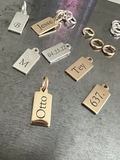 "A sideways display of your name, initials, or a short word makes for an intriguing look with our sleek tag charm. We will engrave your name or message in vertical display on this 14k gold-filled shiny pendant and ring to hang on your own chain. CHAIN NOT INCLUDED Free Engraving for a limited time! CHARM DETAILS * 14k gold-filled or 925 sterling silver * Tag measures 13.5mm x 6mm (.53\" x .23\") * Large jump ring to slide on to your favorite chain * Choice of several fonts and design layouts * U Small Blank Rectangular Sterling Silver Writeable Gift Tag, Customizable Modern Nameplate Jewelry, Modern Customizable Nameplate Jewelry, Silver Rectangular Custom Name Jewelry, Sterling Silver Nameplate Charms Jewelry, Modern Nameplate Jewelry For Personalized Gift, Meaningful Silver Rectangular Jewelry, Personalized Rectangular Charms Jewelry, Dainty Personalized Charms For Anniversary