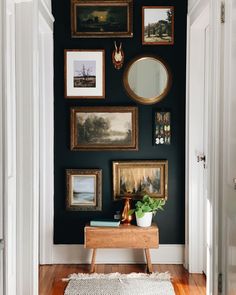 an entryway with pictures on the wall and a rug in front of it,