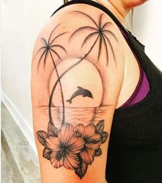 a woman's arm with flowers and palm trees on it