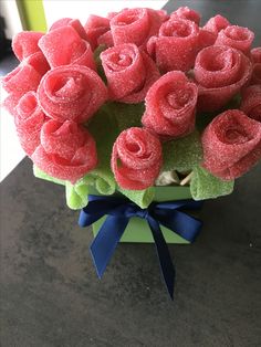 a bouquet of red roses sitting on top of a green vase filled with watermelon