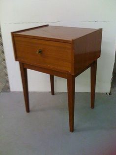 a small wooden table with one drawer on the top and two drawers on the bottom