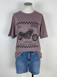 Rev up your style with our Vintage Motorcycle Tee in Zinc! This graphic tee is both cute and comfy, featuring a bold motorcycle graphic and trendy mineral wash. Perfect for adding some edge to any outfit. Ride in style! Due to mineral washing color may vary Length: 28" 100% Cotton Brand: BLT Trendy Acid Wash Cotton T-shirt, Washed Black Graphic Print Top For Everyday, Everyday Washed Black Tops With Graphic Print, Everyday Acid Wash Graphic Tee, Everyday Washed Black Top With Graphic Print, Cotton Biker Tops With Letter Print, Everyday Washed Black Graphic T-shirt, Everyday Washed Black T-shirt With Graphic Print, Everyday Grunge Acid Wash T-shirt