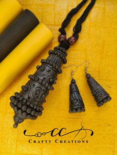 the necklace and earring are made out of black wood with intricate designs on it