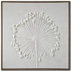 a white wall hanging on the side of a building with an intricately designed flower design