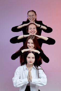 four women in black and white shirts are doing yoga poses with their hands on their heads