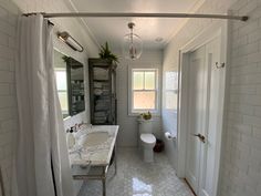 a bathroom with a toilet, sink and shower curtained in to the side walk