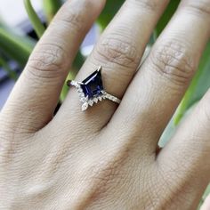 a woman's hand with a ring on it and a blue stone in the middle