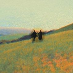 two people are walking through the grass on a hill